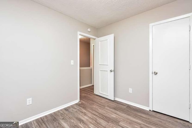 unfurnished bedroom featuring a textured ceiling and light wood-type flooring