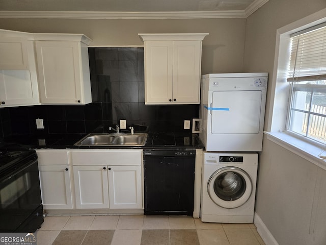 kitchen with white cabinets, sink, stacked washer and clothes dryer, and black appliances