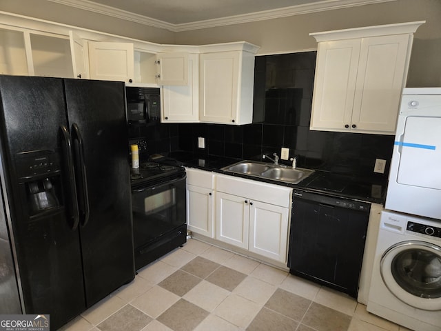 kitchen with stacked washer and clothes dryer, black appliances, sink, decorative backsplash, and white cabinetry