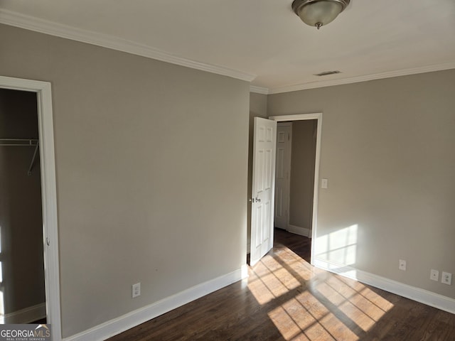 unfurnished bedroom featuring a closet, wood-type flooring, and ornamental molding