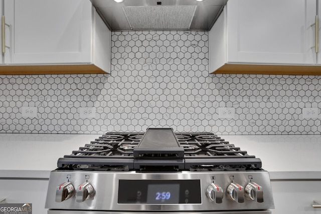 kitchen featuring white cabinets, wall chimney range hood, and backsplash