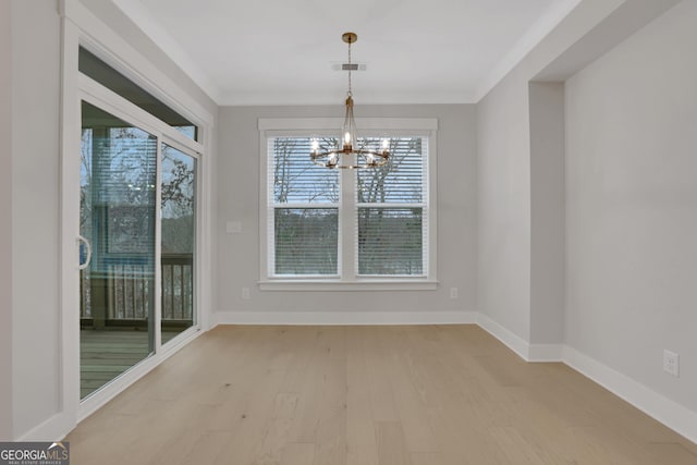 unfurnished dining area featuring a chandelier, light hardwood / wood-style flooring, and a healthy amount of sunlight