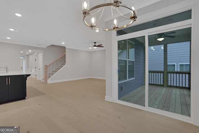 unfurnished living room featuring light hardwood / wood-style floors and ceiling fan with notable chandelier