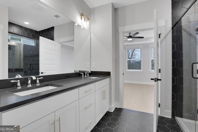 bathroom with tile patterned floors, ceiling fan, a shower with door, and vanity