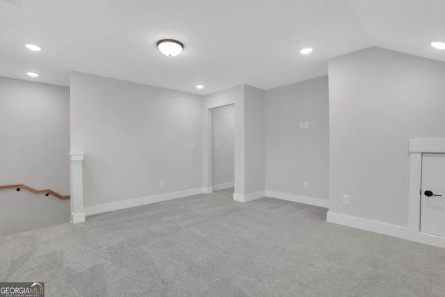 unfurnished room with light carpet and lofted ceiling