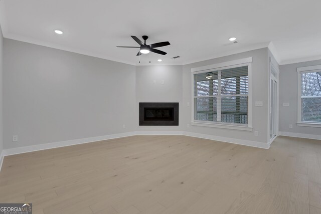 unfurnished living room featuring light hardwood / wood-style floors, ceiling fan, and crown molding