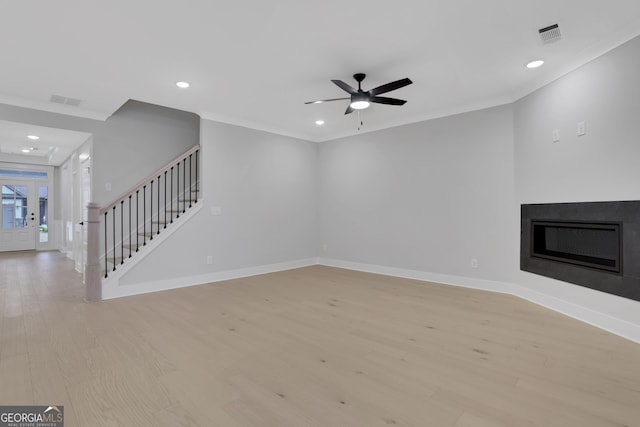 unfurnished living room featuring light hardwood / wood-style floors, ceiling fan, and ornamental molding