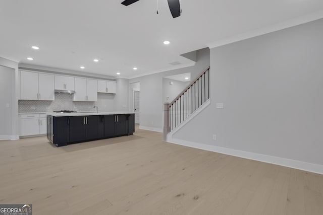 kitchen with ornamental molding, light hardwood / wood-style floors, white cabinetry, and a large island