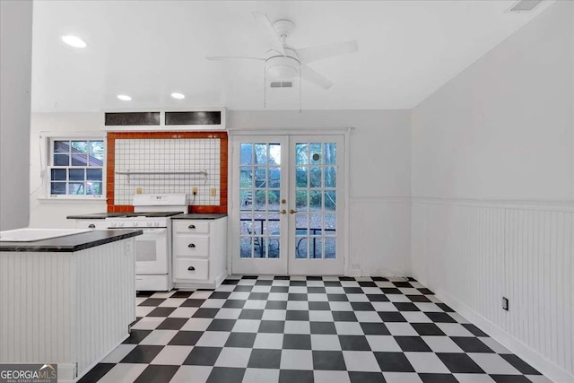 kitchen featuring french doors, ceiling fan, tasteful backsplash, white range oven, and white cabinetry