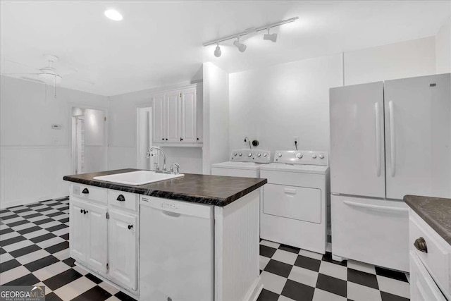 kitchen with sink, separate washer and dryer, white appliances, a center island with sink, and white cabinets