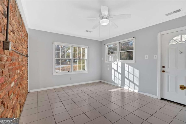 entryway with ceiling fan, light tile patterned floors, crown molding, and brick wall