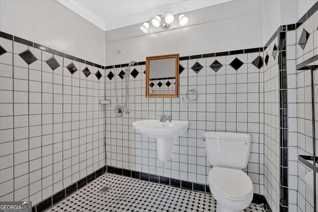 bathroom with toilet, tile walls, and crown molding