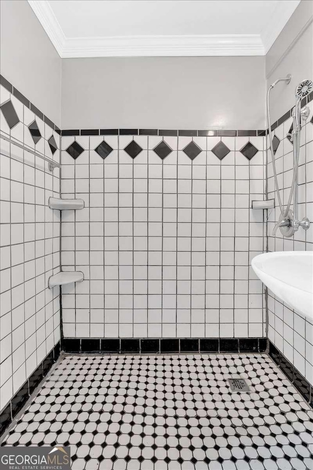 bathroom featuring a tile shower and ornamental molding