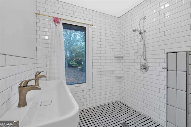 bathroom featuring sink and tile walls