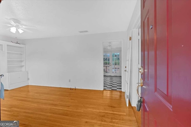 entrance foyer featuring ceiling fan, french doors, and light wood-type flooring