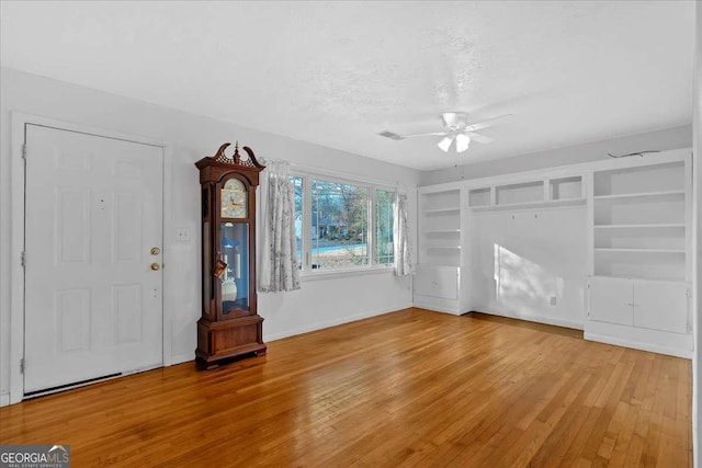 unfurnished living room featuring wood-type flooring, a textured ceiling, and ceiling fan