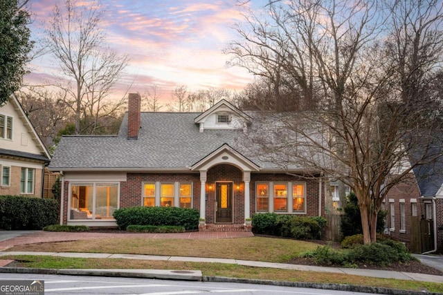 new england style home featuring a lawn