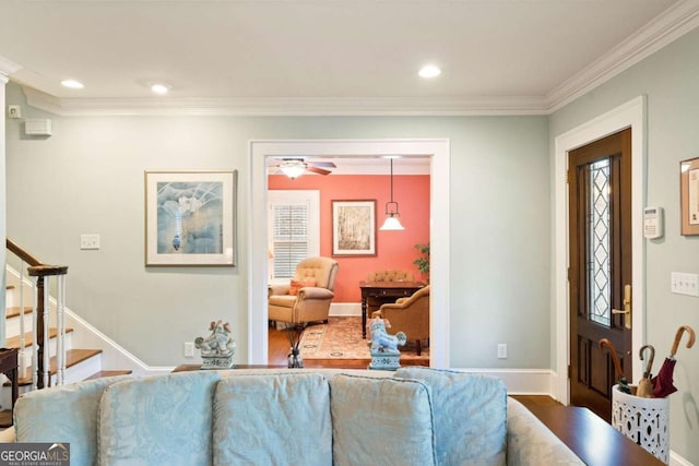 living room with hardwood / wood-style flooring, ceiling fan, and crown molding