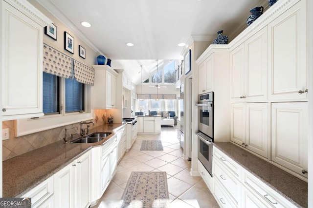 kitchen with ceiling fan, sink, tasteful backsplash, dark stone counters, and light tile patterned floors