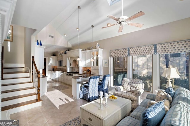 tiled living room featuring ceiling fan and high vaulted ceiling