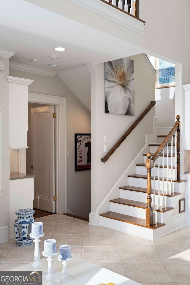 stairs with crown molding and tile patterned flooring