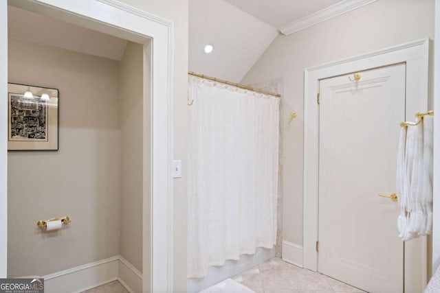 bathroom with lofted ceiling, tile patterned floors, and crown molding