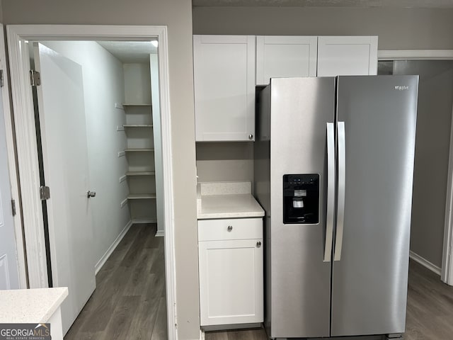 kitchen with stainless steel fridge with ice dispenser, dark hardwood / wood-style floors, and white cabinetry