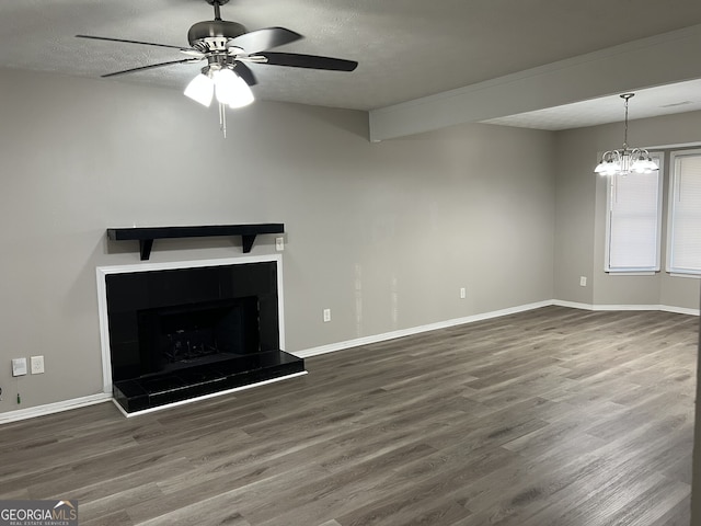 unfurnished living room featuring a textured ceiling, ceiling fan with notable chandelier, and dark hardwood / wood-style floors