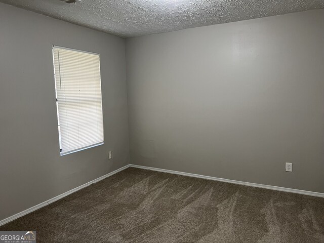 carpeted spare room with a textured ceiling