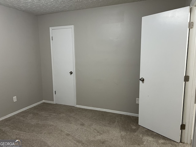 spare room with carpet flooring and a textured ceiling