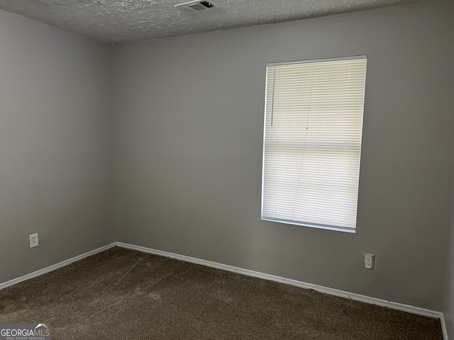 carpeted spare room featuring a textured ceiling