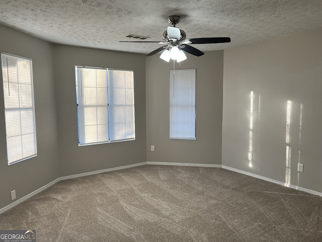 carpeted empty room with ceiling fan and a textured ceiling