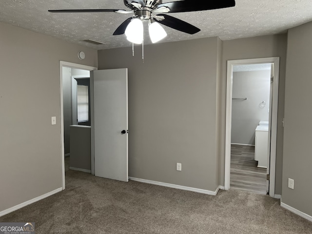 unfurnished bedroom with carpet flooring, ceiling fan, and a textured ceiling