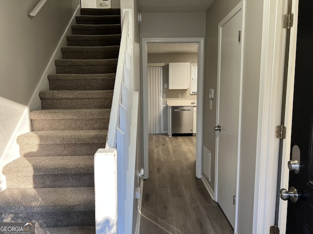 staircase with hardwood / wood-style floors