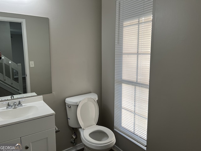 bathroom featuring plenty of natural light, vanity, and toilet