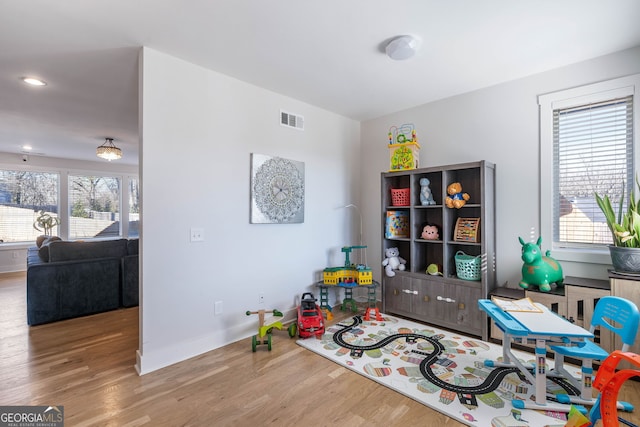 game room featuring hardwood / wood-style floors and a healthy amount of sunlight