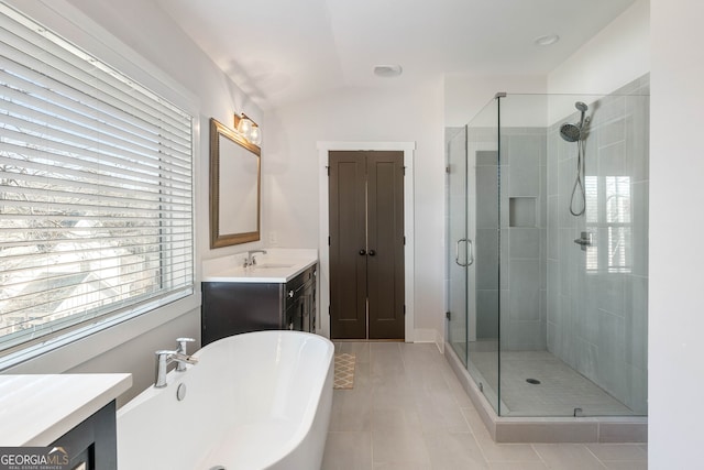 bathroom with tile patterned floors, vanity, vaulted ceiling, and independent shower and bath