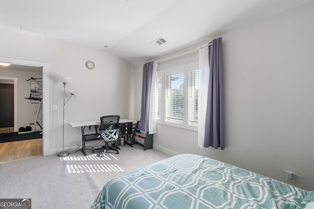 bedroom featuring light carpet and lofted ceiling