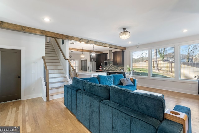 living room featuring beam ceiling and light hardwood / wood-style floors