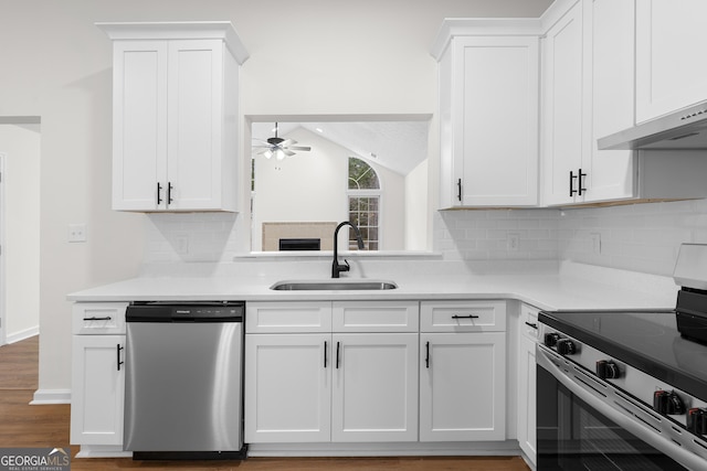 kitchen featuring stainless steel appliances, ceiling fan, sink, white cabinetry, and lofted ceiling