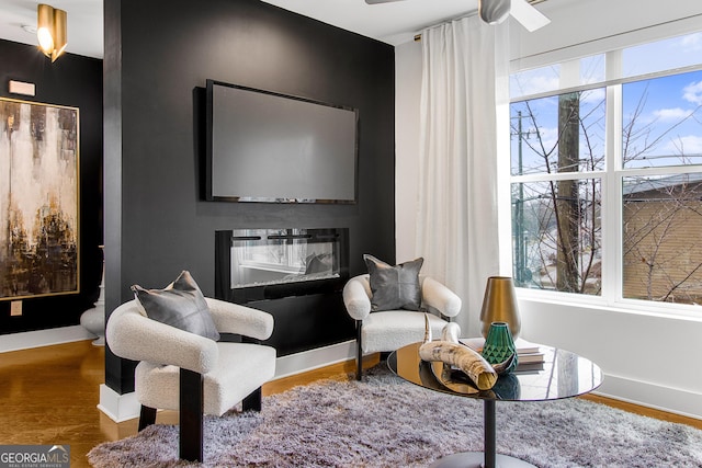 living area with ceiling fan and wood-type flooring