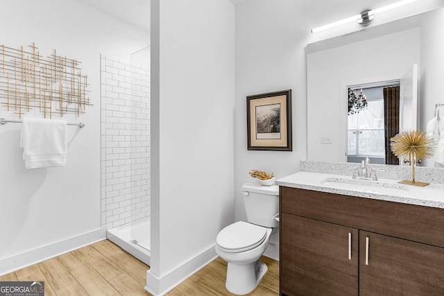 bathroom featuring tiled shower, vanity, and toilet