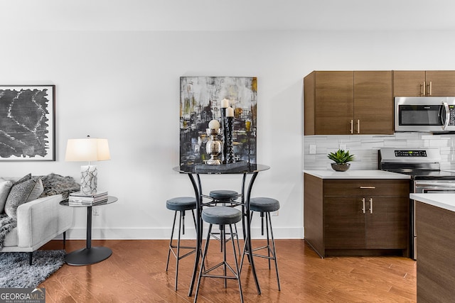 kitchen with stainless steel appliances, tasteful backsplash, and light hardwood / wood-style floors