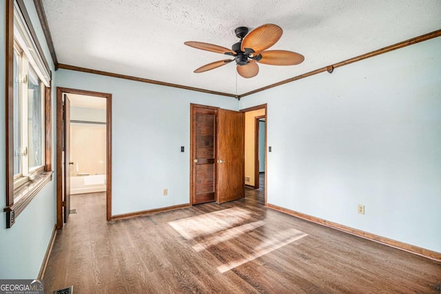 unfurnished bedroom with hardwood / wood-style flooring, ceiling fan, crown molding, and a textured ceiling