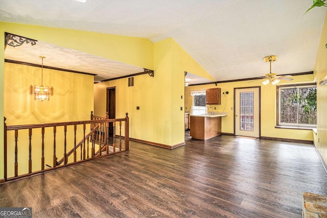 spare room with ceiling fan with notable chandelier, dark hardwood / wood-style flooring, and lofted ceiling