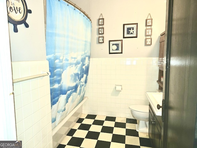 full bathroom with toilet, vanity, tile walls, and shower / bath combo