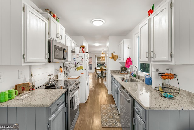 kitchen featuring light stone counters, sink, white cabinets, and stainless steel appliances