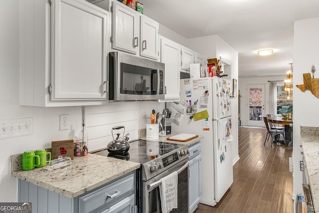 kitchen featuring light stone counters, dark hardwood / wood-style flooring, white cabinets, and stainless steel appliances