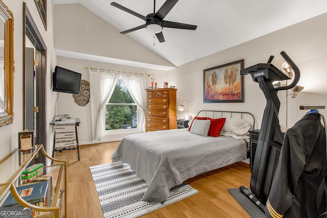 bedroom featuring a textured ceiling, light hardwood / wood-style floors, vaulted ceiling, and ceiling fan