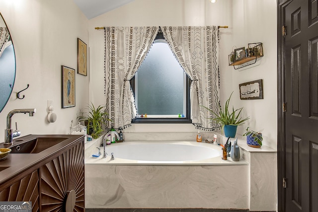 bathroom with a tub to relax in, sink, and vaulted ceiling